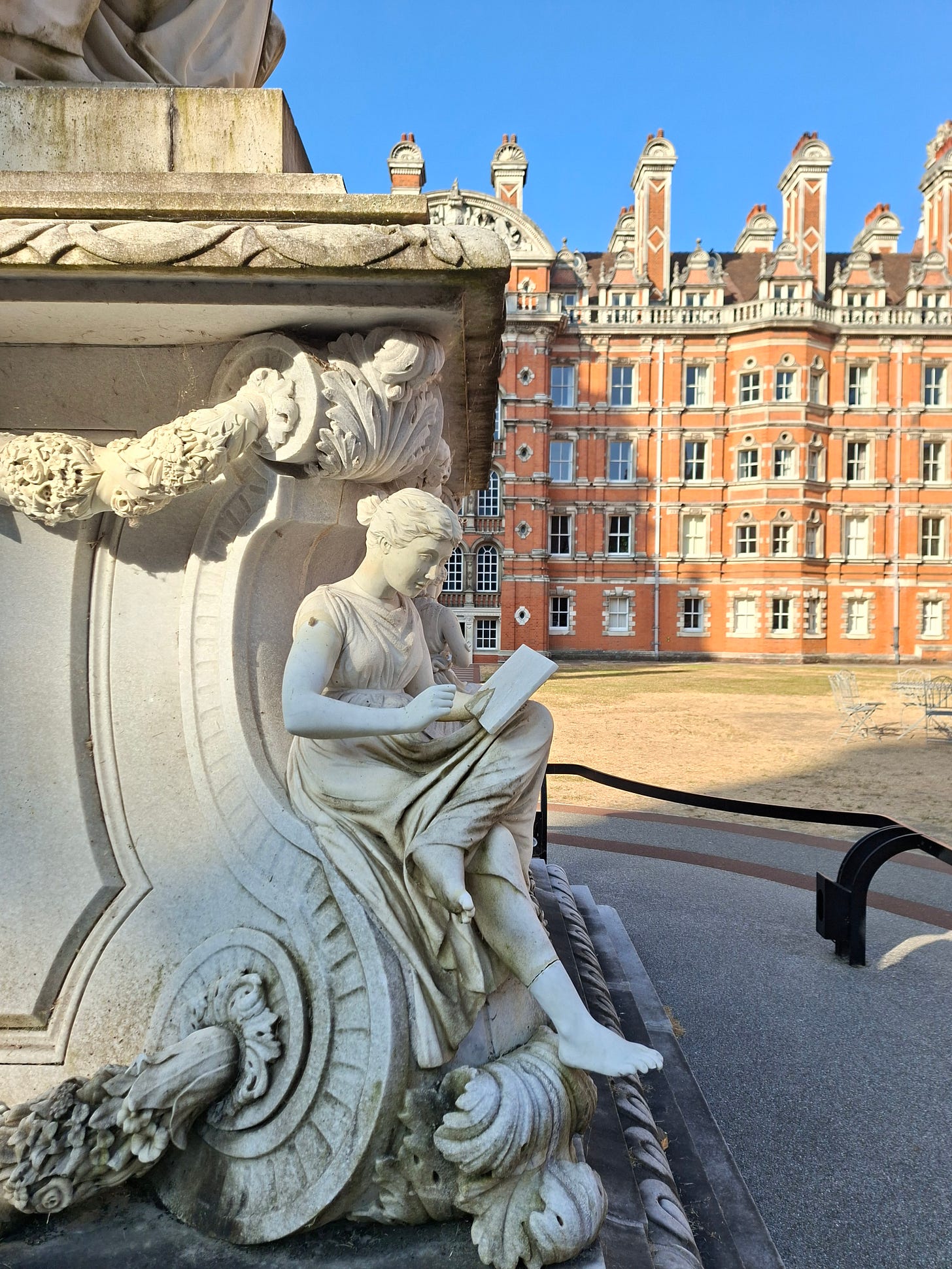 marble statue of a woman reading a tablet