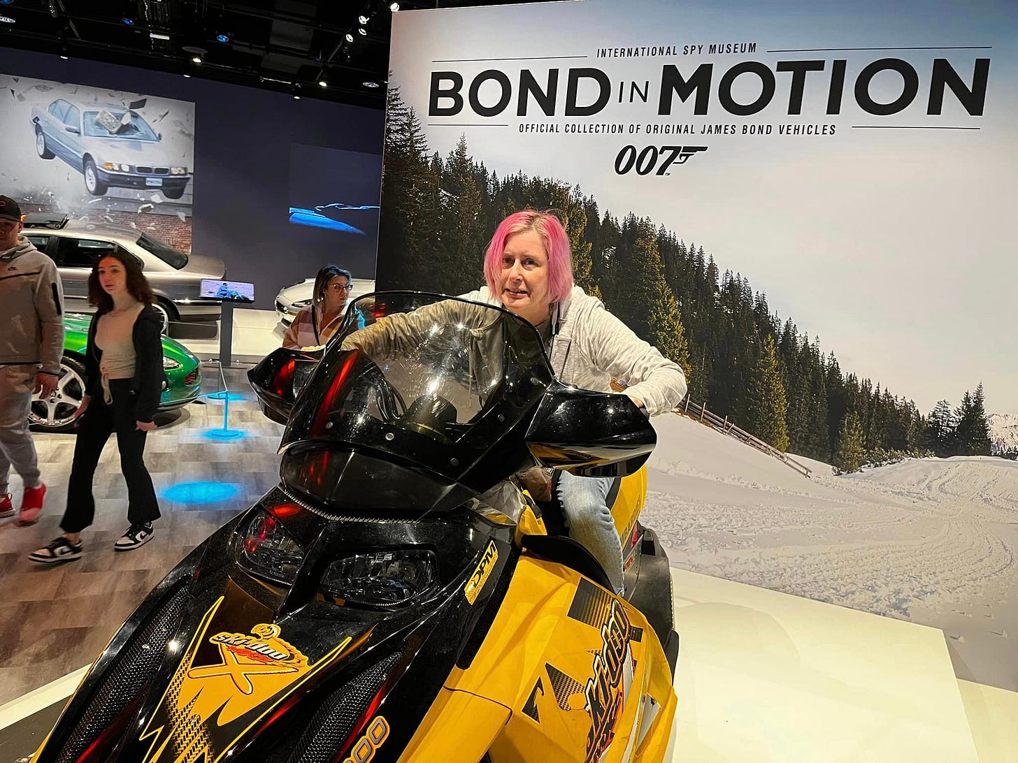 May be an image of 4 people and text that says "INTERNATIONAL SPY BOND IN MOTION MUSEUM OFFICIAL COLLECTION OF ORIGINAL JAMES BOND VEHICLES 0075 007"