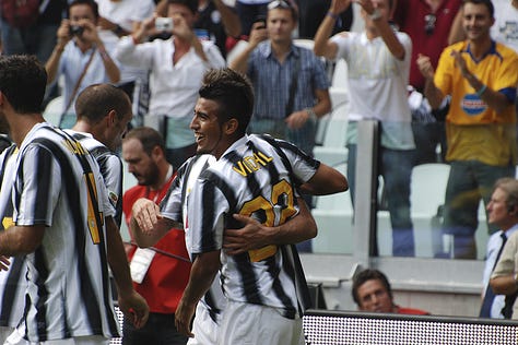 Juventus vs Parma, September 11, 2011: Arturo Vidal celebrates scoring on his debut, Juventus players embrace, fans erupt in celebration, Del Piero and teammates on the pitch, and Gianluigi Buffon giving a thumbs up during the opening match at Juventus Stadium.