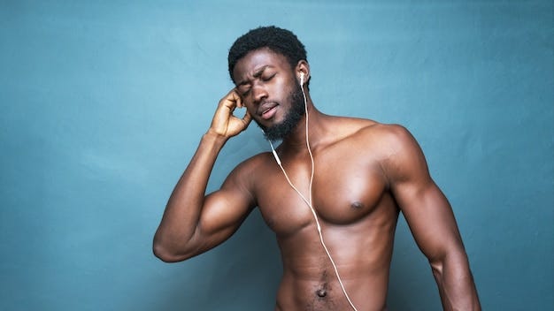 Hot young topless african man listening to music with earphones on a blue | Free Photo Hot young topless african man listening to music with earphones on a blue | Free Photo