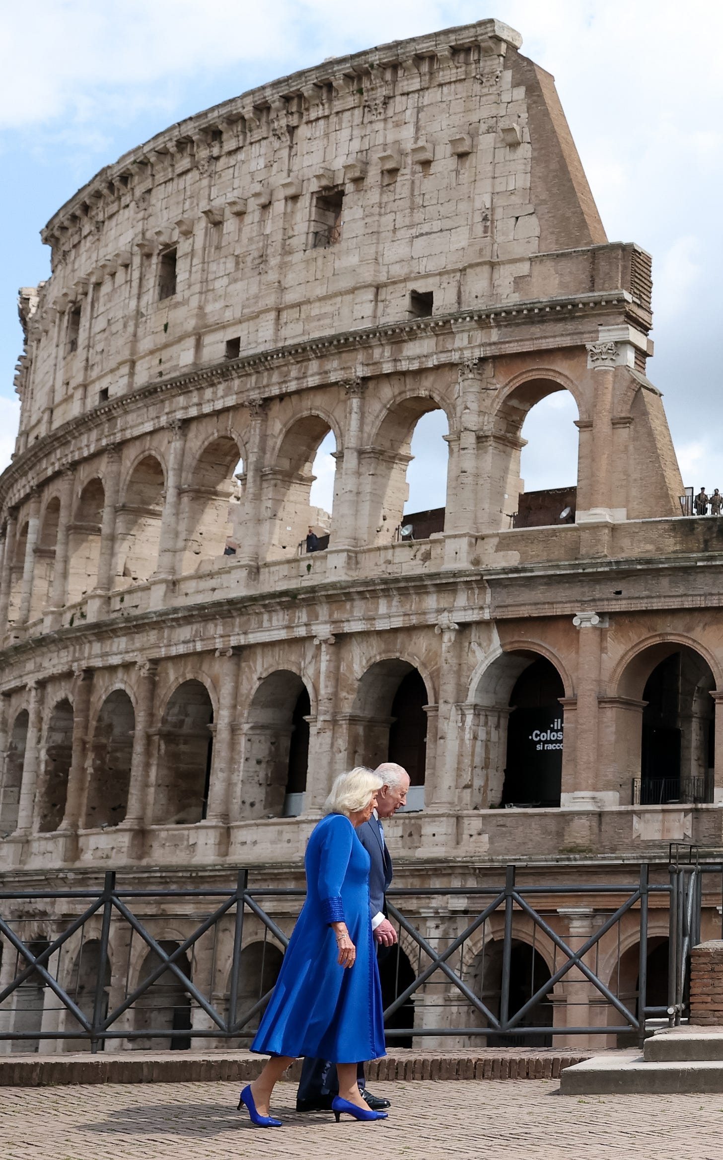 Man and woman walking in front of Colosseum