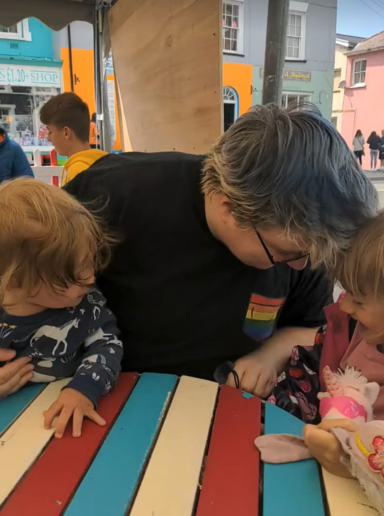 a pciture of a androgynous looking person with two small children
