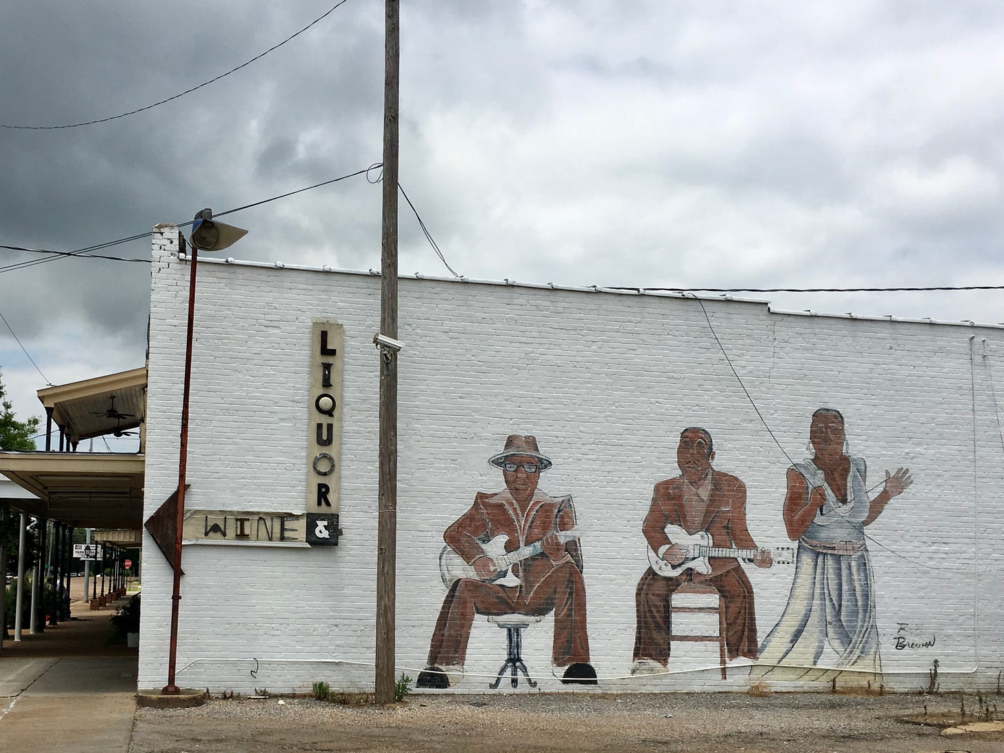 Mural painted on the side of a building showing John Lee Hooker, Muddy Waters, and Bessie Smith