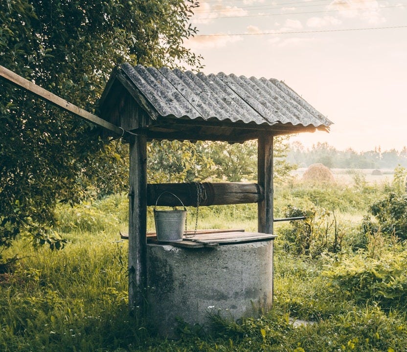 a well in the middle of a grassy field
