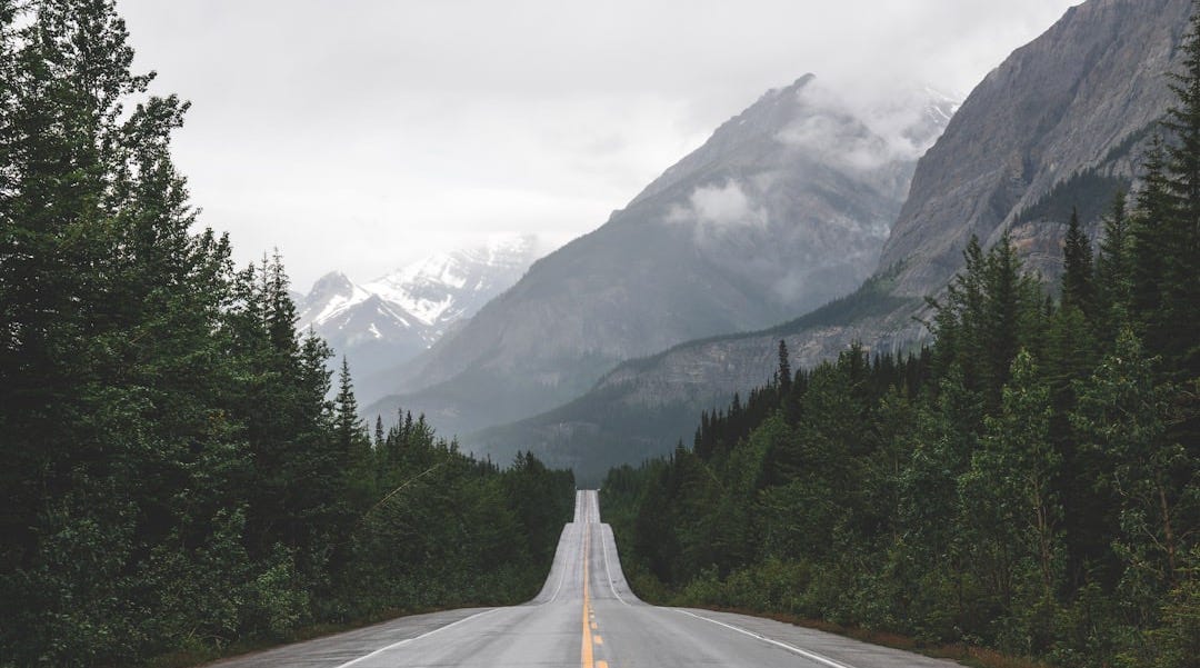 a long road with a mountain in the background