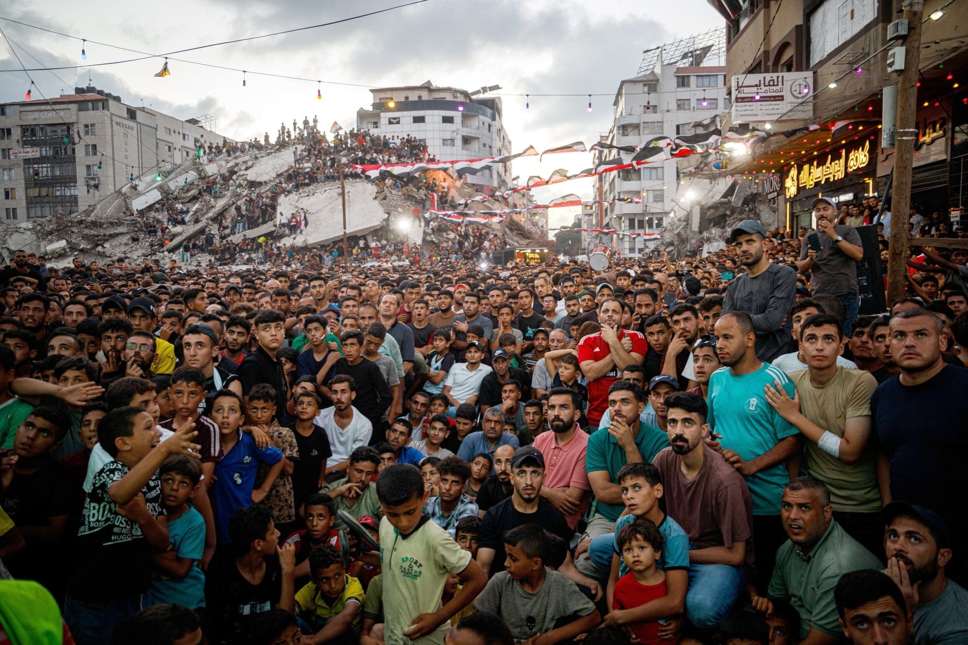 A huge crowd gather, some standing on the rubble of a ruined building, to watch Argentina play Egypt. Photograph: Mohammed Skaik/TheNews2/Cover Images
