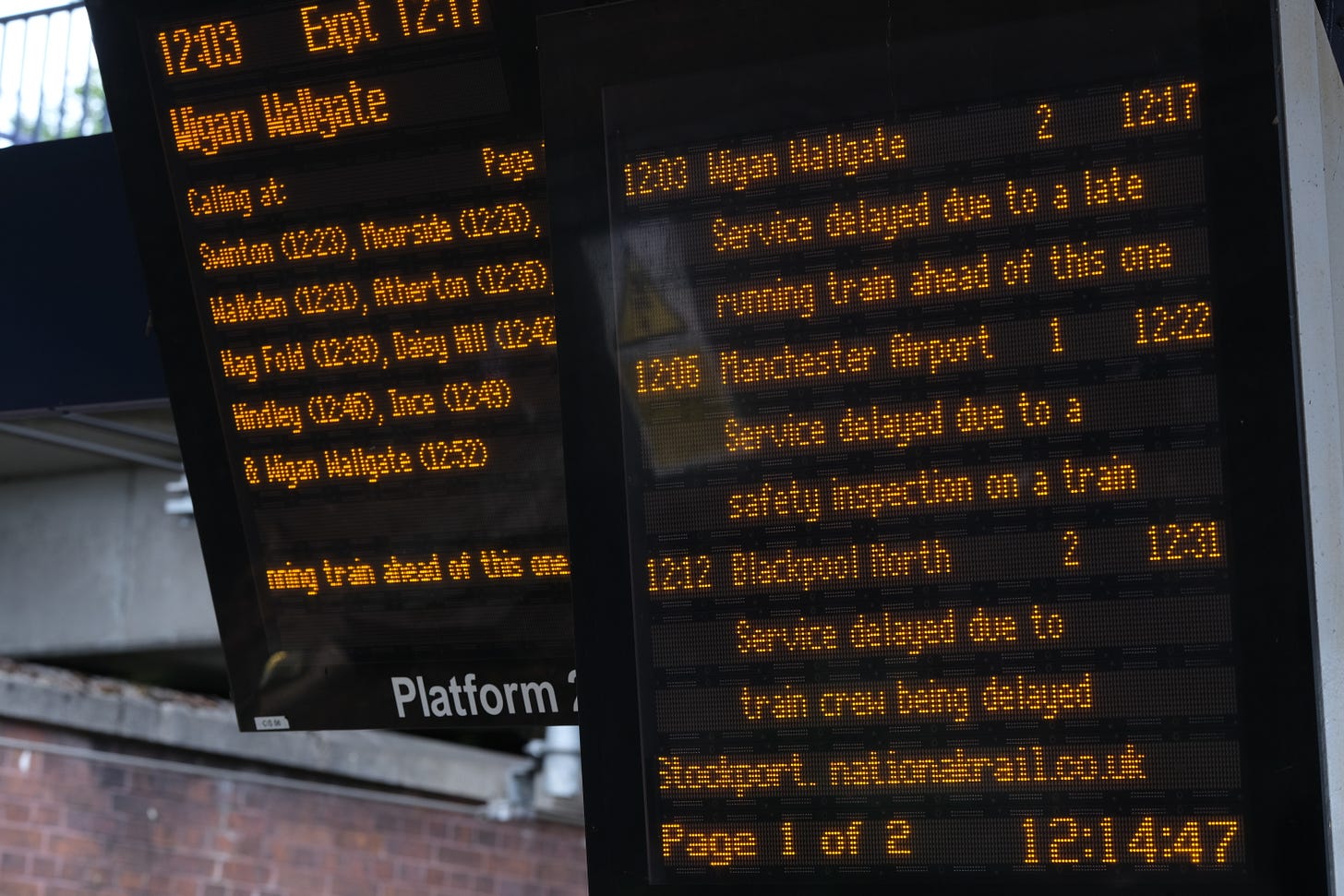 Two train boards that say 'delayed' on them.