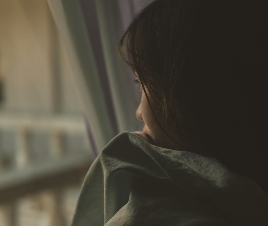 woman in black shirt looking at window