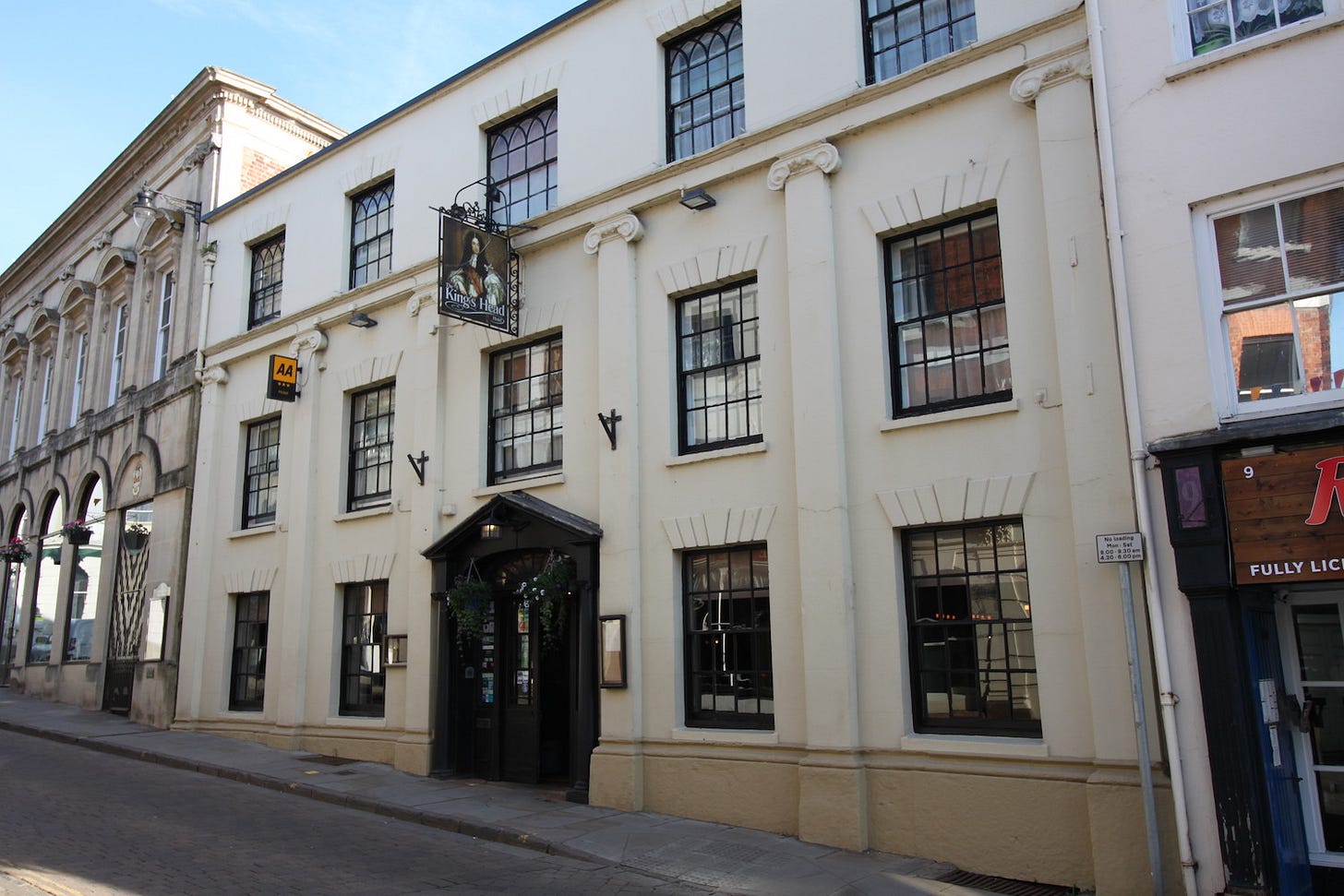A hotel building with a sign above the door - The Kings Head - Ross-on-Wye