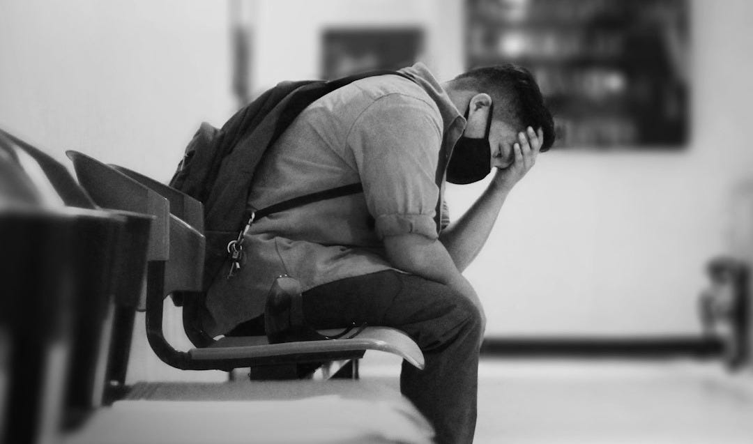 man in black jacket sitting on chair man in black jacket sitting on chair