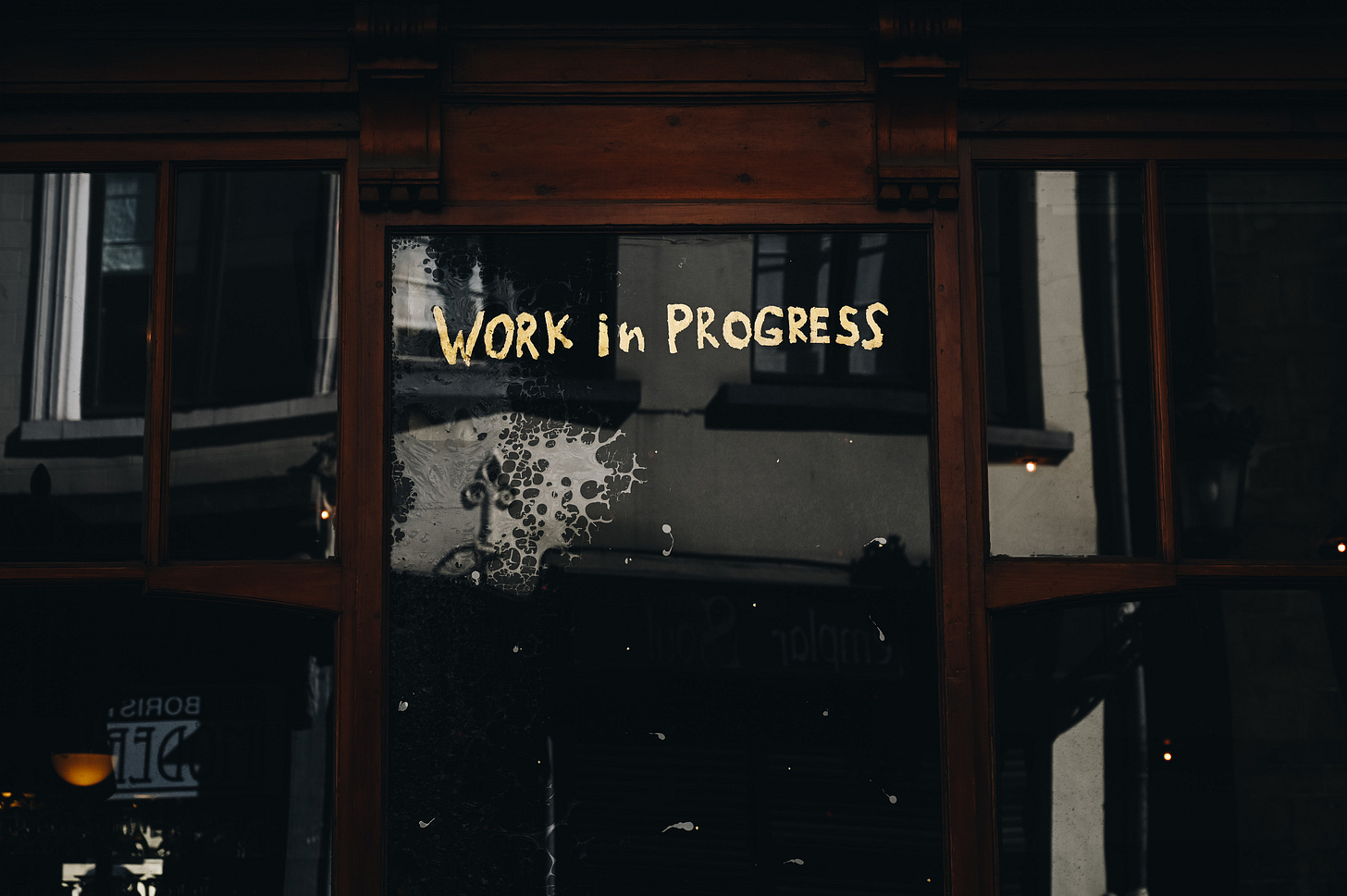 A sign on a window that says "work in progress" A sign on a window that says "work in progress"