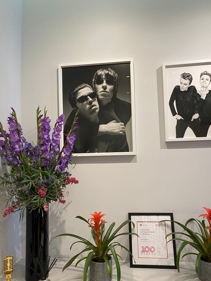 picture frames of Beatles album covers and photographs of Liam & Noel Gallagher and David Bowie.