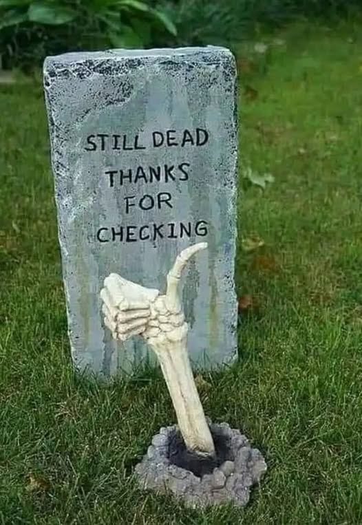 An image of text that says 'STILL DEAD THANKS FOR CHECK CHECKING ING' while a skeletal hand reaches out of a grave giving the thumbs up.