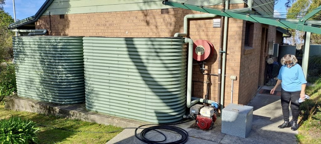 Margaret Gough next to her water tanks 
