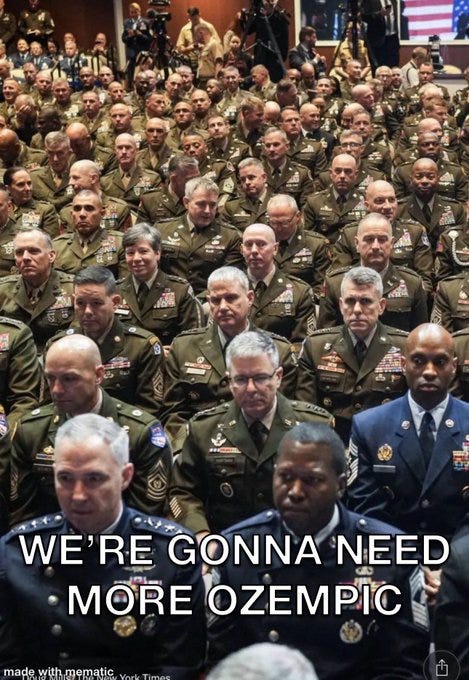 A large group of military personnel in uniform, including generals, seated in rows at a formal event. Many wear military attire with medals and insignia. Text overlay reads "WE\'RE GONNA NEED MORE OZEMPIC" in bold white letters. A watermark from the New York Times is visible. A large group of military personnel in uniform, including generals, seated in rows at a formal event. Many wear military attire with medals and insignia. Text overlay reads "WE\'RE GONNA NEED MORE OZEMPIC" in bold white letters. A watermark from the New York Times is visible.