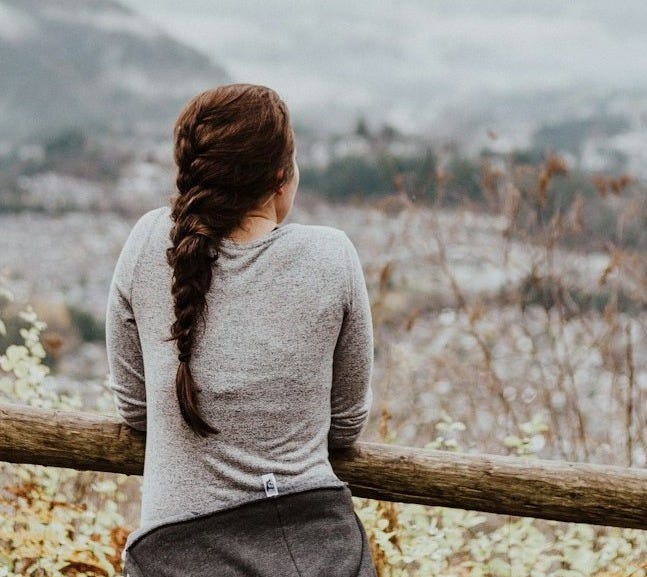 standing woman in grey long-sleeved shirt standing woman in grey long-sleeved shirt