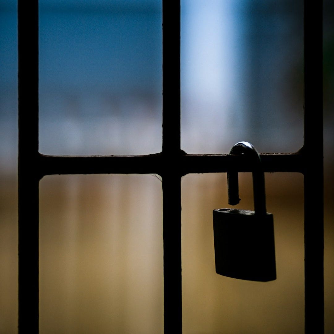 brass padlock on black metal fence brass padlock on black metal fence