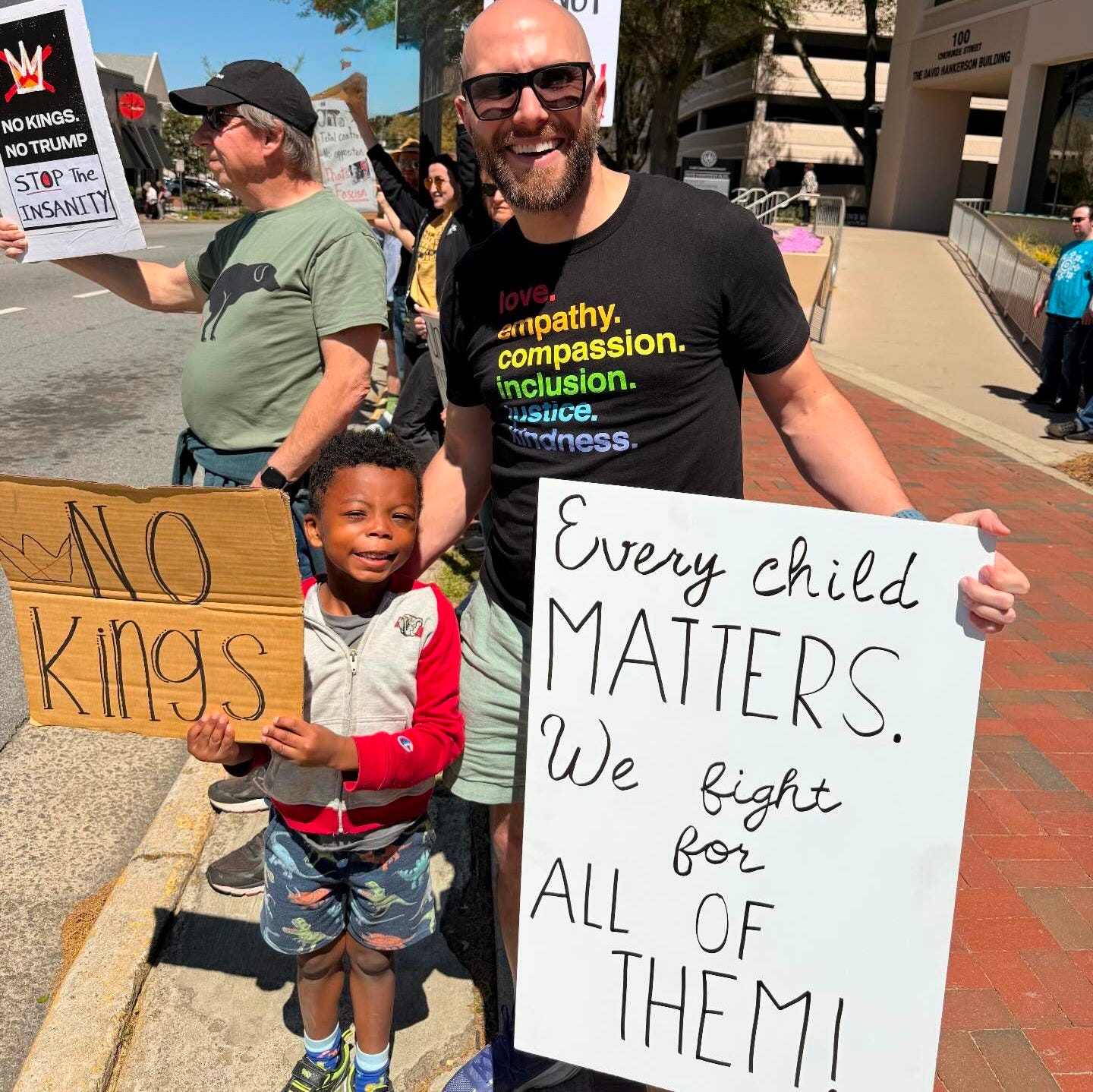 May be an image of standing and text that says '9 RAGE ACAINST M NO NO KINGS. NO NO TRUMP STOP The the INSANITY mpathy. compassion. inclusion. ndness. UStIce NO kings Every child MATTERS. We fight ALL for OF THEM!'