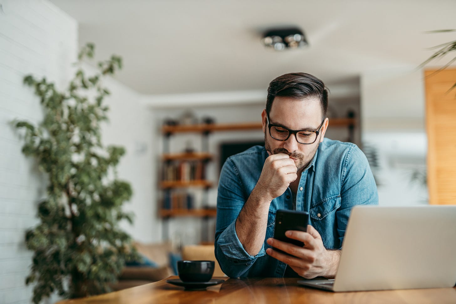 Puzzled looking man holding smartphone