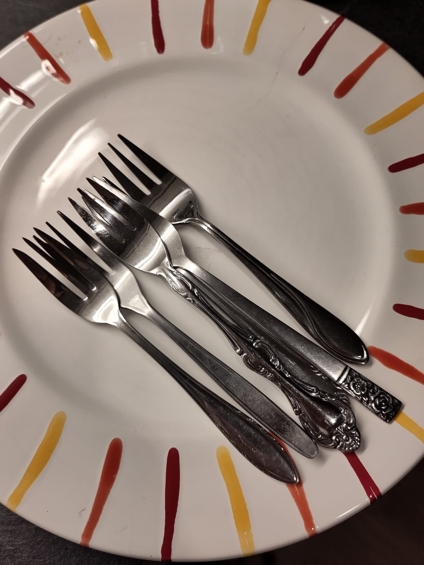 A plate and seven small forks lying on the plate bring me joy.
