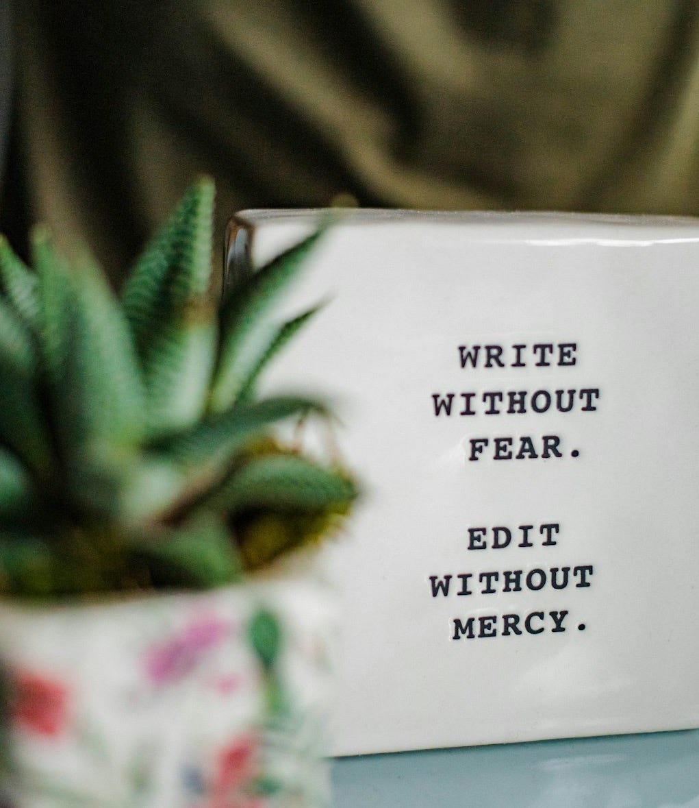 a white box with writing on it next to a plant