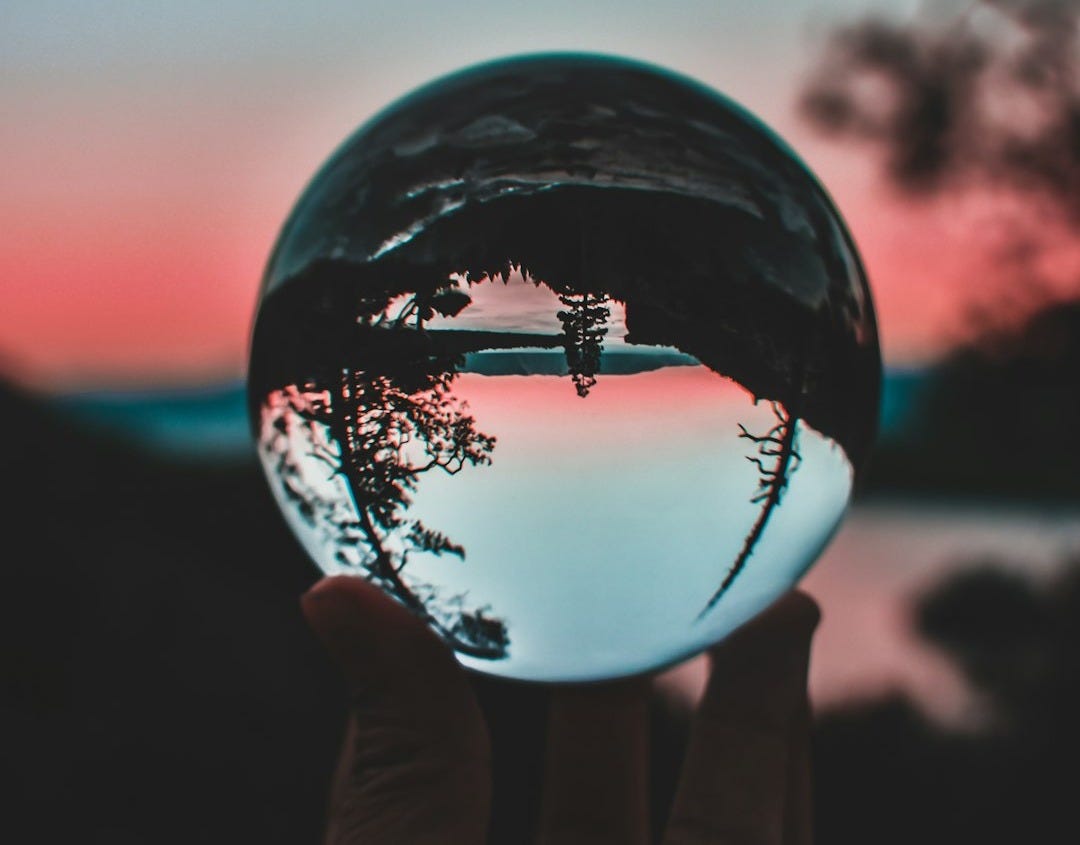 person holding clear crystal ball