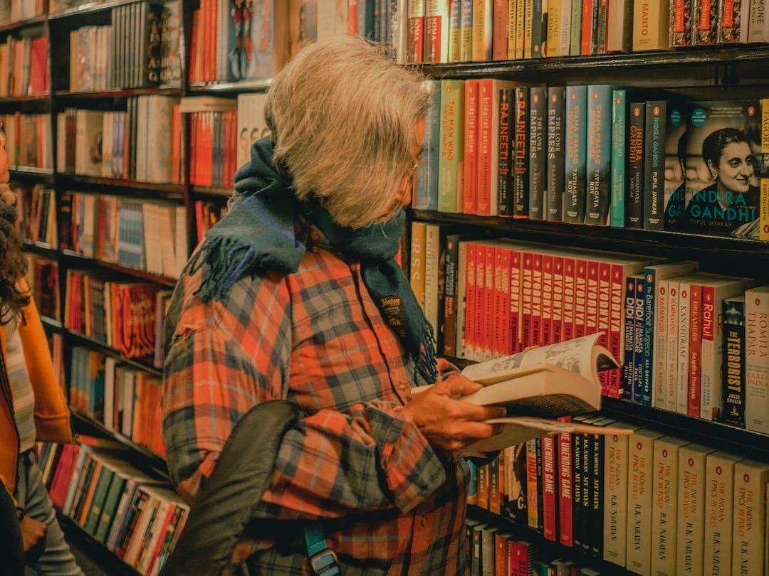 woman in blue and red plaid dress shirt reading book