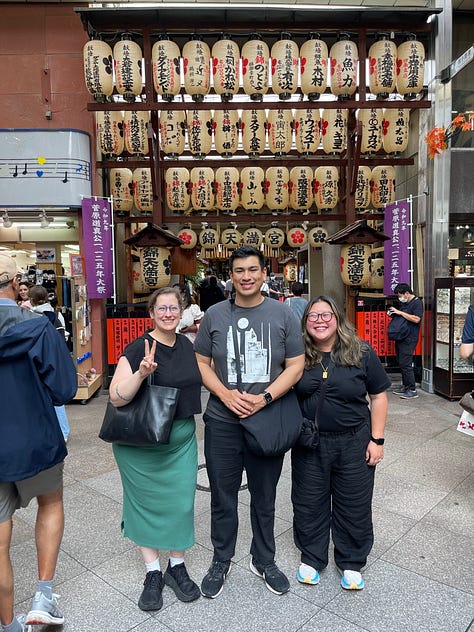 A collage of nine photos from travels in Japan: two sumo wrestlers posing with visitors; vintage kabuki posters on display; a small group sitting on tatami mats during a cultural workshop; a mannequin dressed in a traditional kimono with floral patterns; three people smiling in front of a lantern-filled temple gate; a night market vendor grilling skewers and takoyaki; two friends taking a selfie in Shibuya among bright city signs; the waterfront skyline and Ferris wheel in Yokohama; and a narrow alleyway in Kyoto lined with glowing izakaya lanterns.