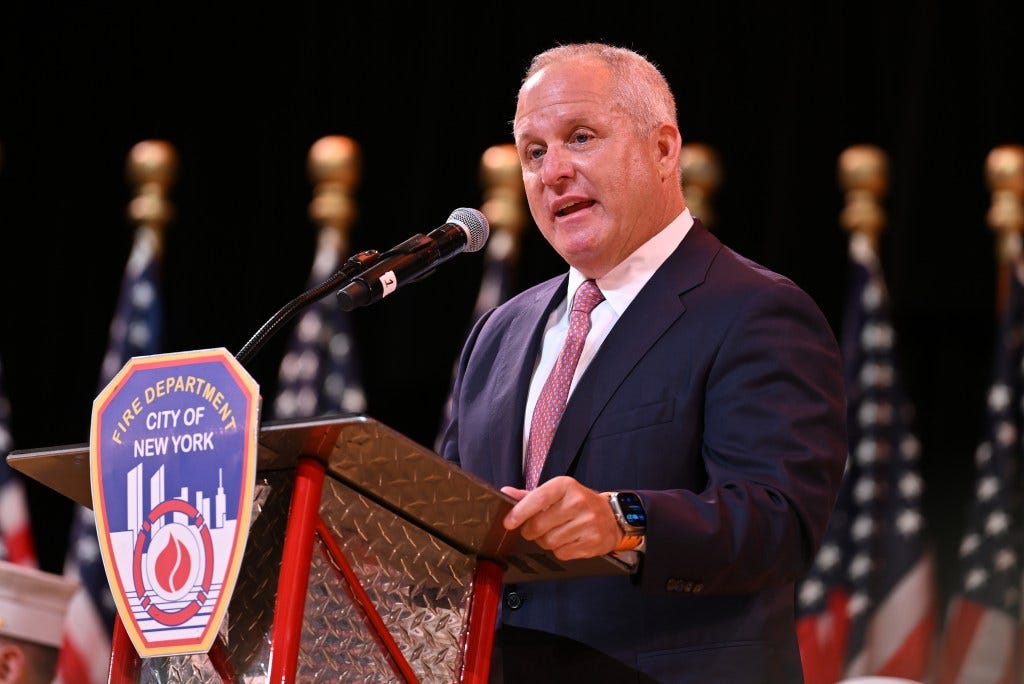 Fire Commissioner Robert Tucker speaking at a podium with a Fire Department City of New York emblem.