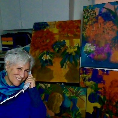 Photo of the author by Sherry Killam Arts using her vintage land line phone against her studio artworks.