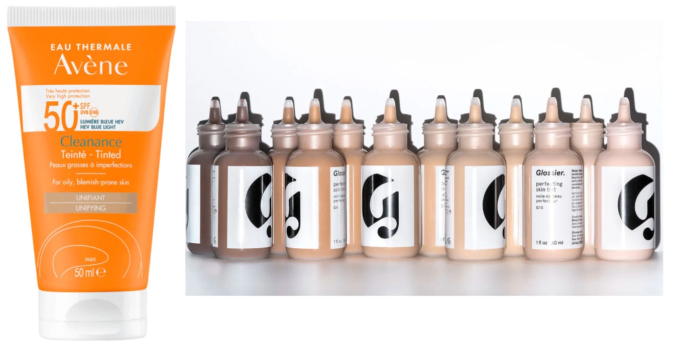 A side-by-line comparison featuring a tube of Avène Cleanance Tinted SPF 50+ for acne-prone skin alongside a diverse range of Glossier Perfecting Skin Tint glass bottles showing various shades.