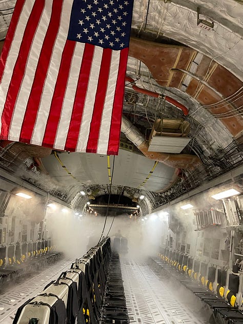 A crew mission planning, an empty cargo bay with mist and the American flag, the back of a C-17 with Presidential vehicles loaded
