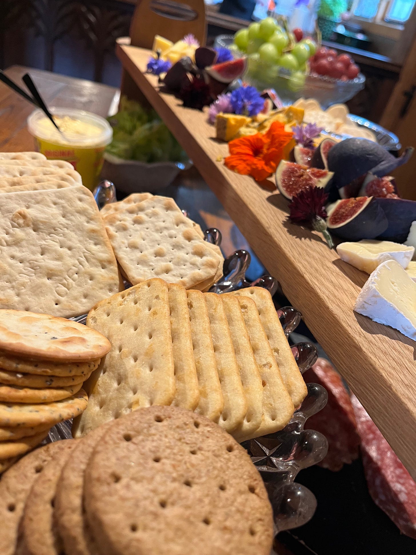 The incredible grazing table style lunch buffet at my WriteFoxy Writing Workshop at the Timber House. A wooden ladder platter holds brie, Harrogate Blue cheese and cheddar surrounded by fresh quartered figs and edible flowers. Beneath the platter are plates of freshly baked rolls and pittas, salad, grapes, olives, spiced red cabbage coleslaw, edamame bean and cous cous salad and pulled pork.