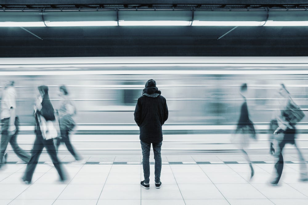 A man at the subway station feeling lonely in between a lot of people A man at the subway station feeling lonely in between a lot of people