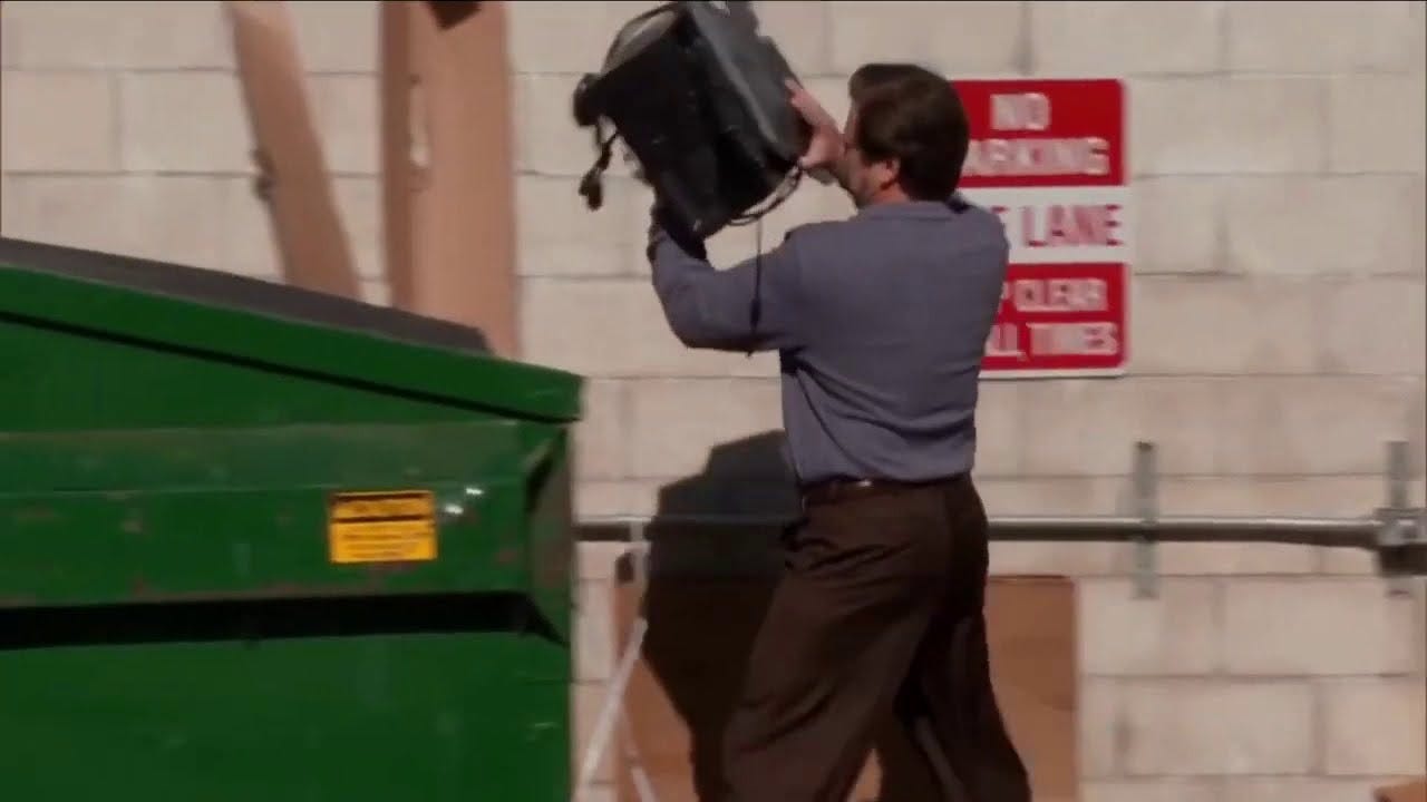 Ron Swanson from the TV show Parks and Recreation throws his computer into a dumpster.