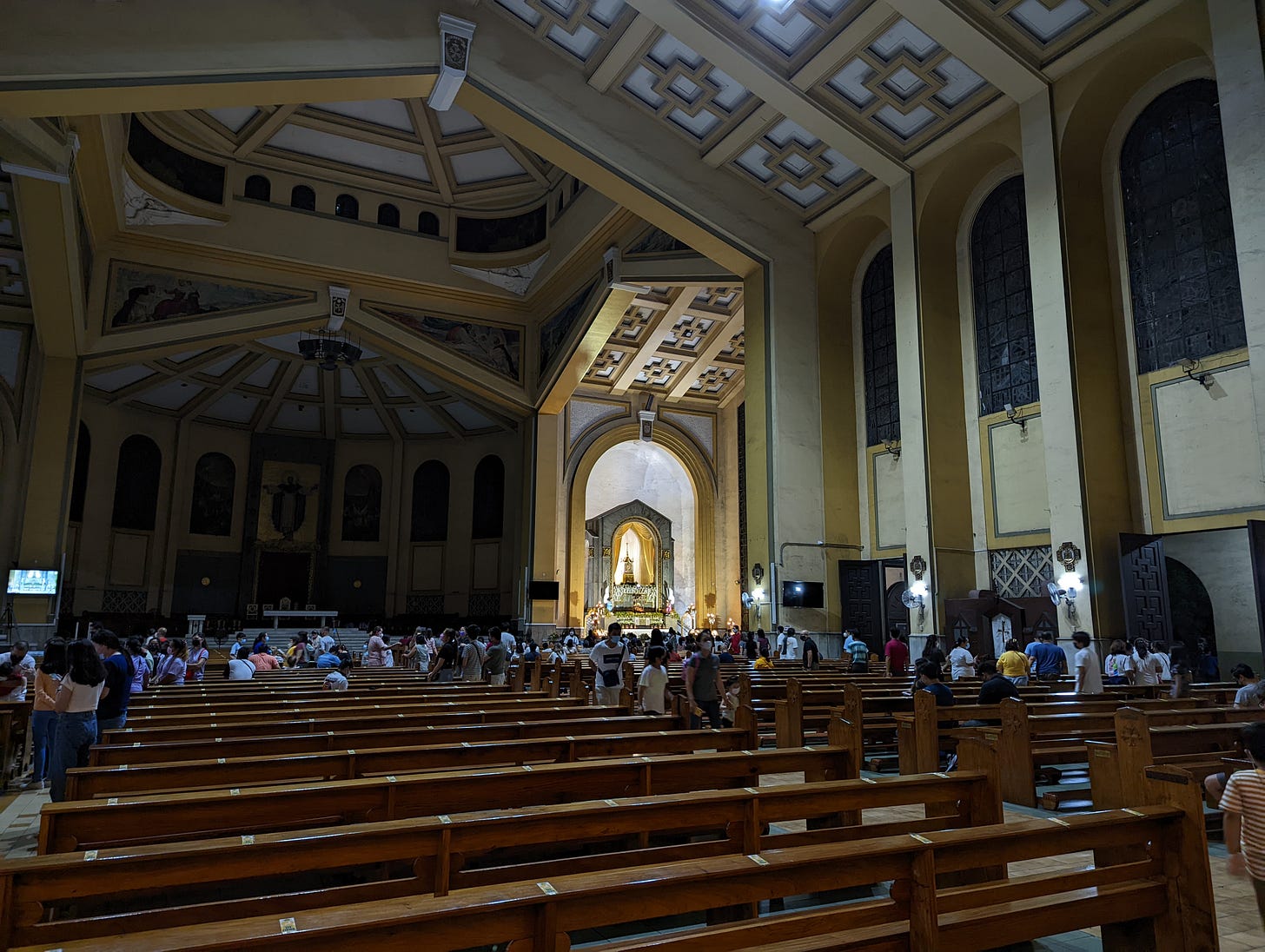 A further shot away from the altar of repose of Santo Domingo Church showing more people and the unlit main altar in front