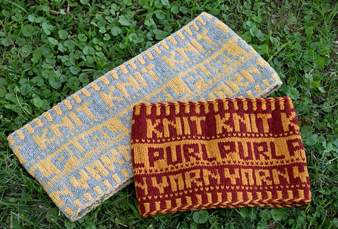 Two colorwork cowls, one in burgundy and gold, the other in gray and yellow, with the words knit, purl, and yarn, on the grass.