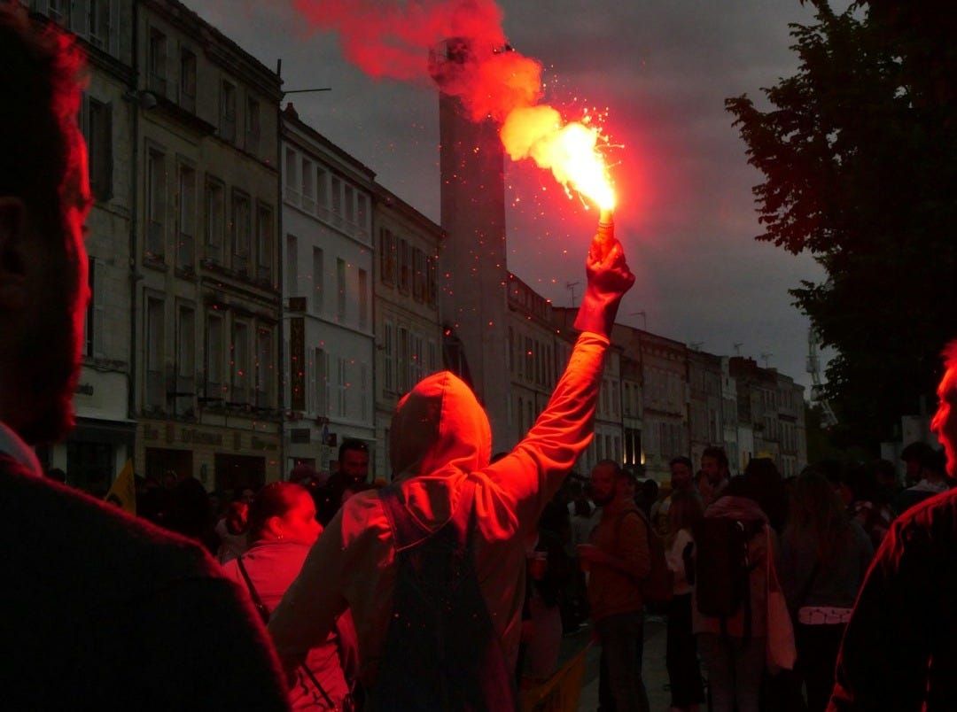 a group of people standing on a street holding flarers
