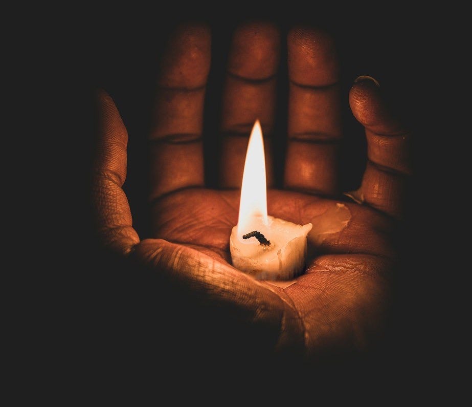 lit candle in hand