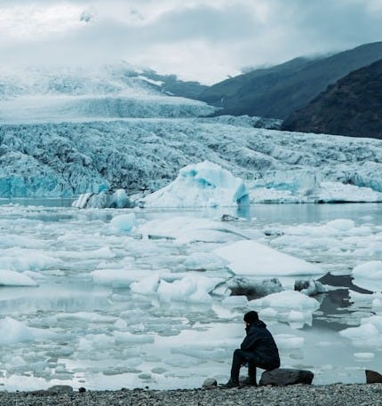 man standing on rock near glaciers