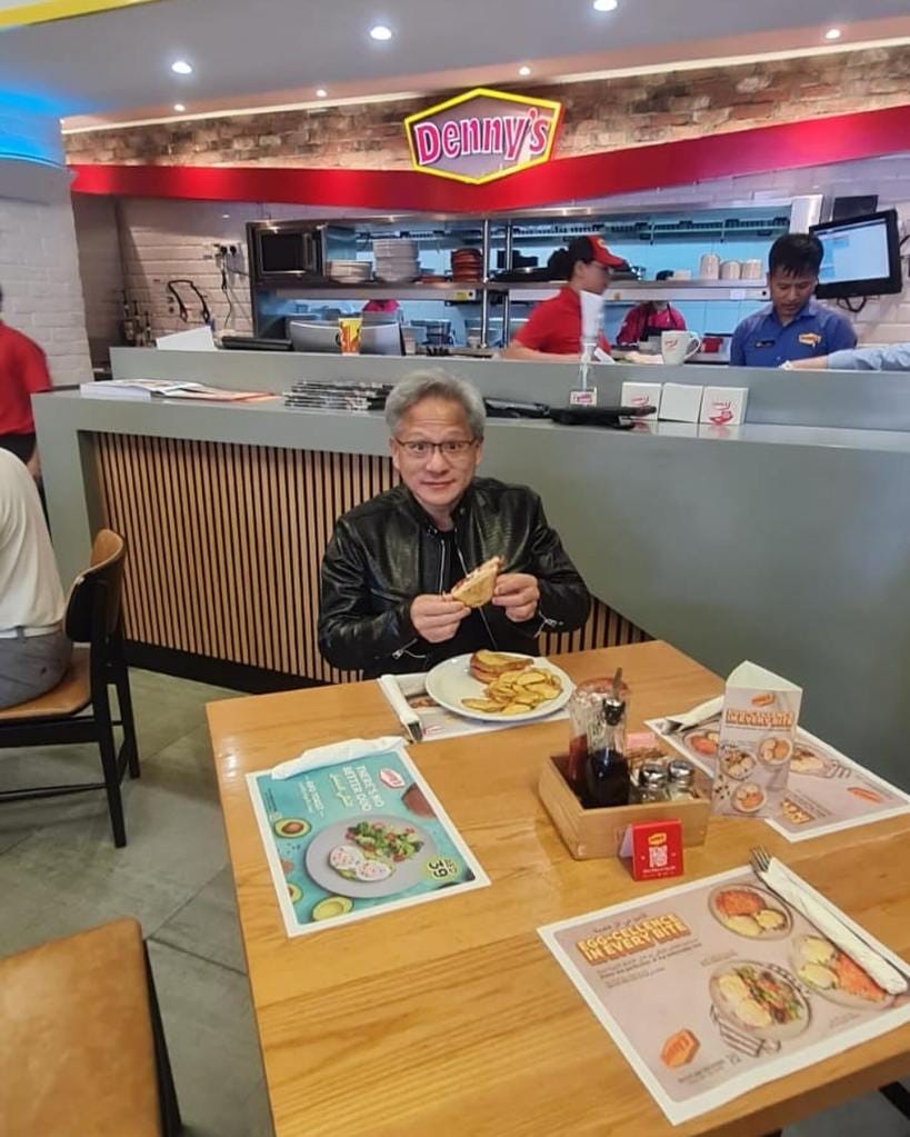Jensen Huang sitting at a table eating food at Denny's Diner, Sheikh Zayed Road, UAE.