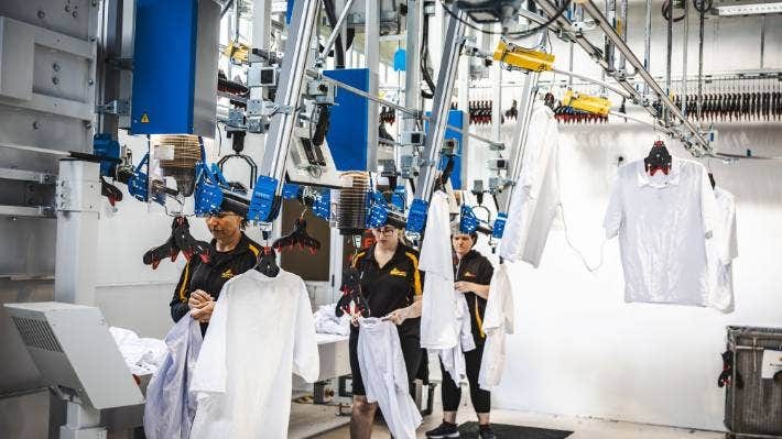 Shirts are hung on hangers and then they travel to their designated destination. Shirts are hung on hangers and then they travel to their designated destination.