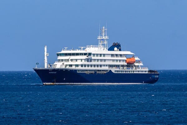 A cruise ship, white with a blue hull, in the open water.