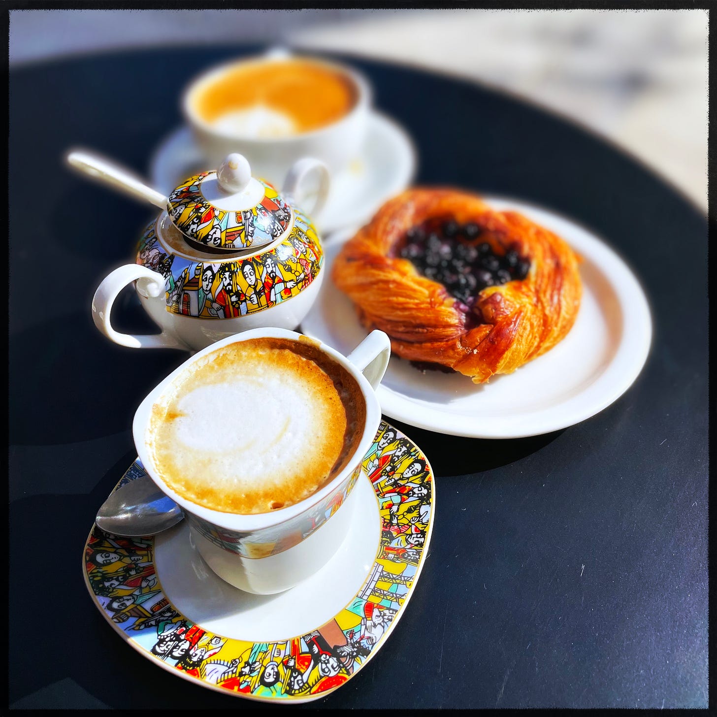 Two cups of coffee and a Danish