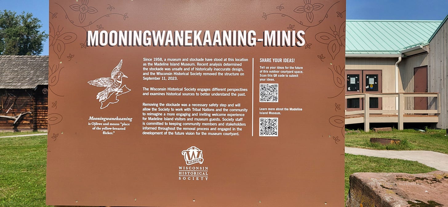 A sign in front of the Madeline Island Museum (La Pointe, Madeline Island), explaining changes to the grounds of the site to work with tribal nations and be more historically accurate.