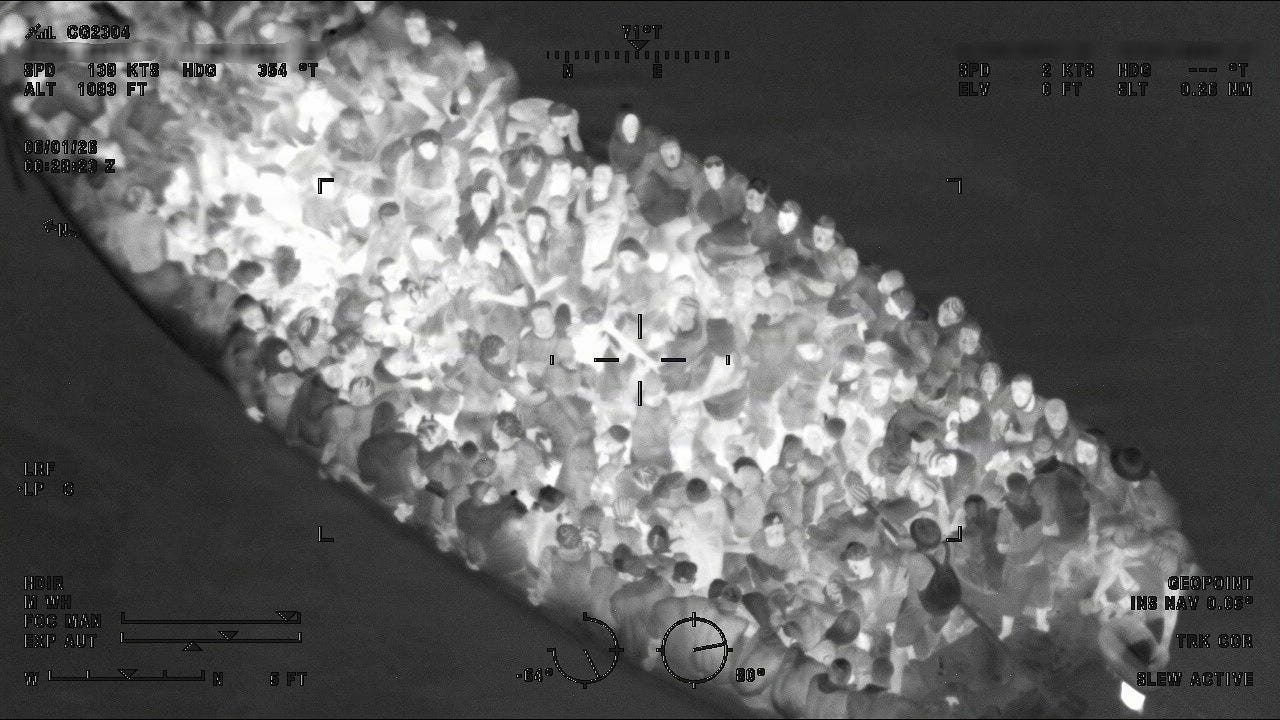 Somewhere, under all these people, is a dangerously overcrowded human smuggling boat underway in the Atlantic Ocean. (US Coast Guard photo) Somewhere, under all these people, is a dangerously overcrowded human smuggling boat underway in the Atlantic Ocean. (US Coast Guard photo)
