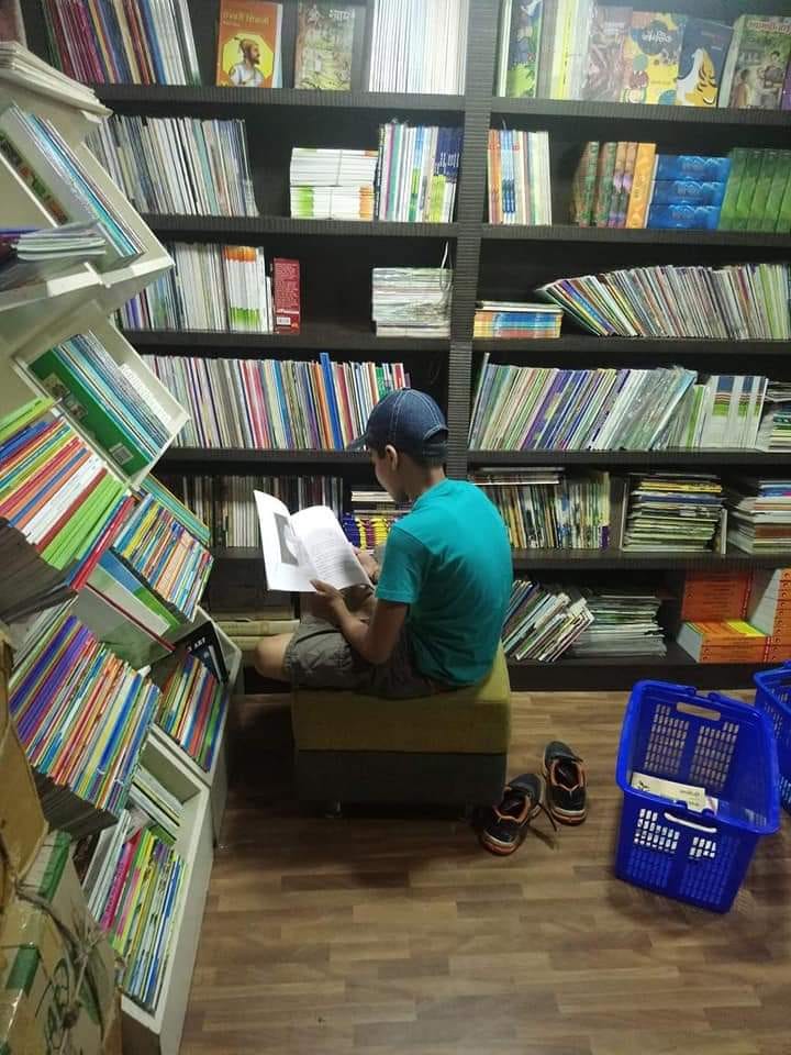Photo of author sitting and reading a book in a bookstore Photo of author sitting and reading a book in a bookstore