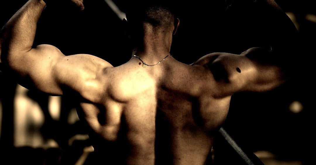 a man flexing his muscles on a balcony