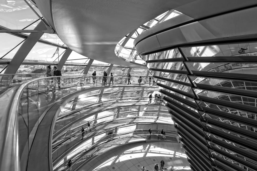 person walking inside clear glass wall building person walking inside clear glass wall building