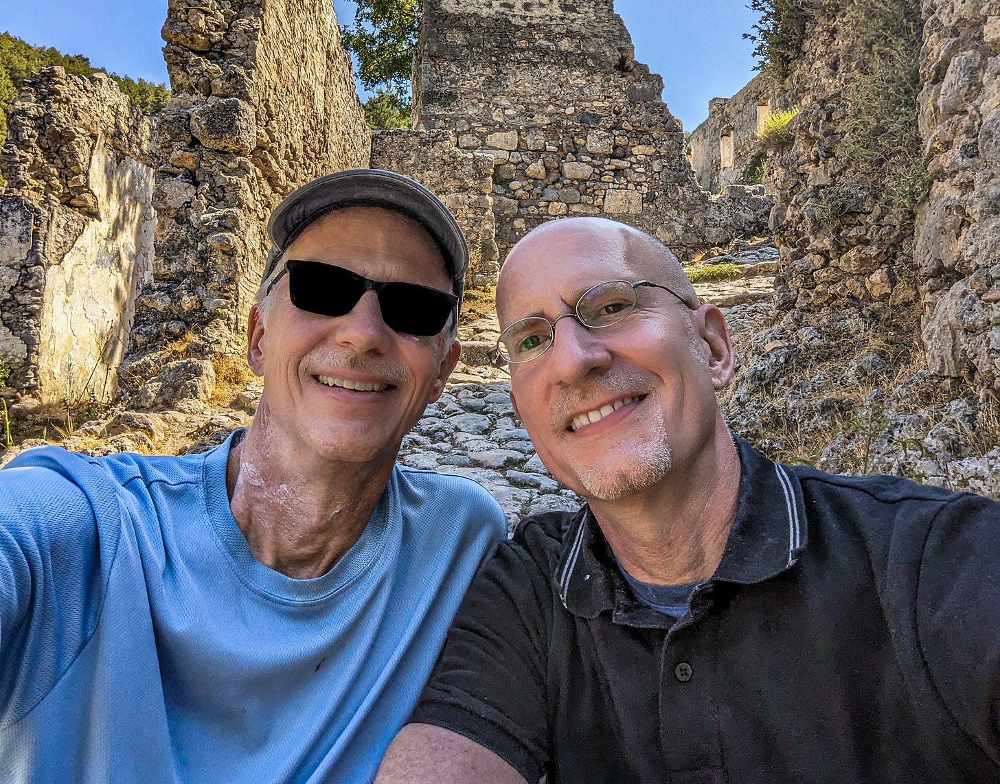 Brent and Michael sitting in front of some ruins. 